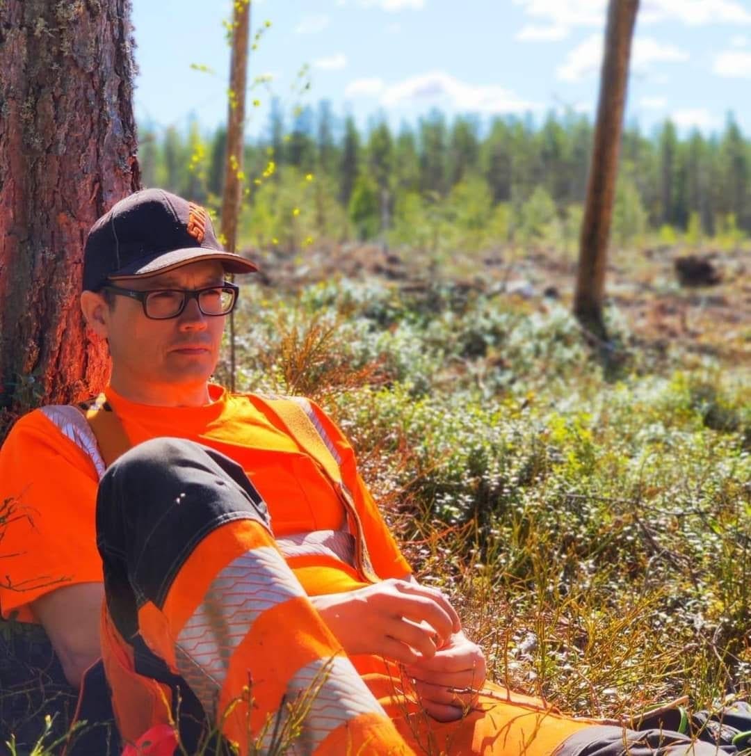 Yrittäjä tauolla puuta vasten kesäisellä uudistusalalla